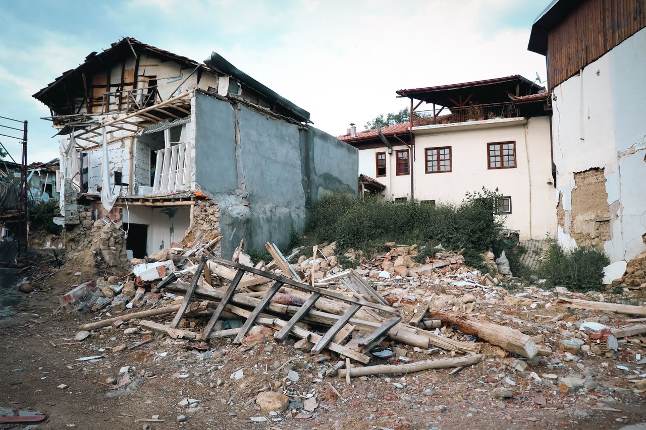 Houses damaged by an earthquake with rubble in the foreground